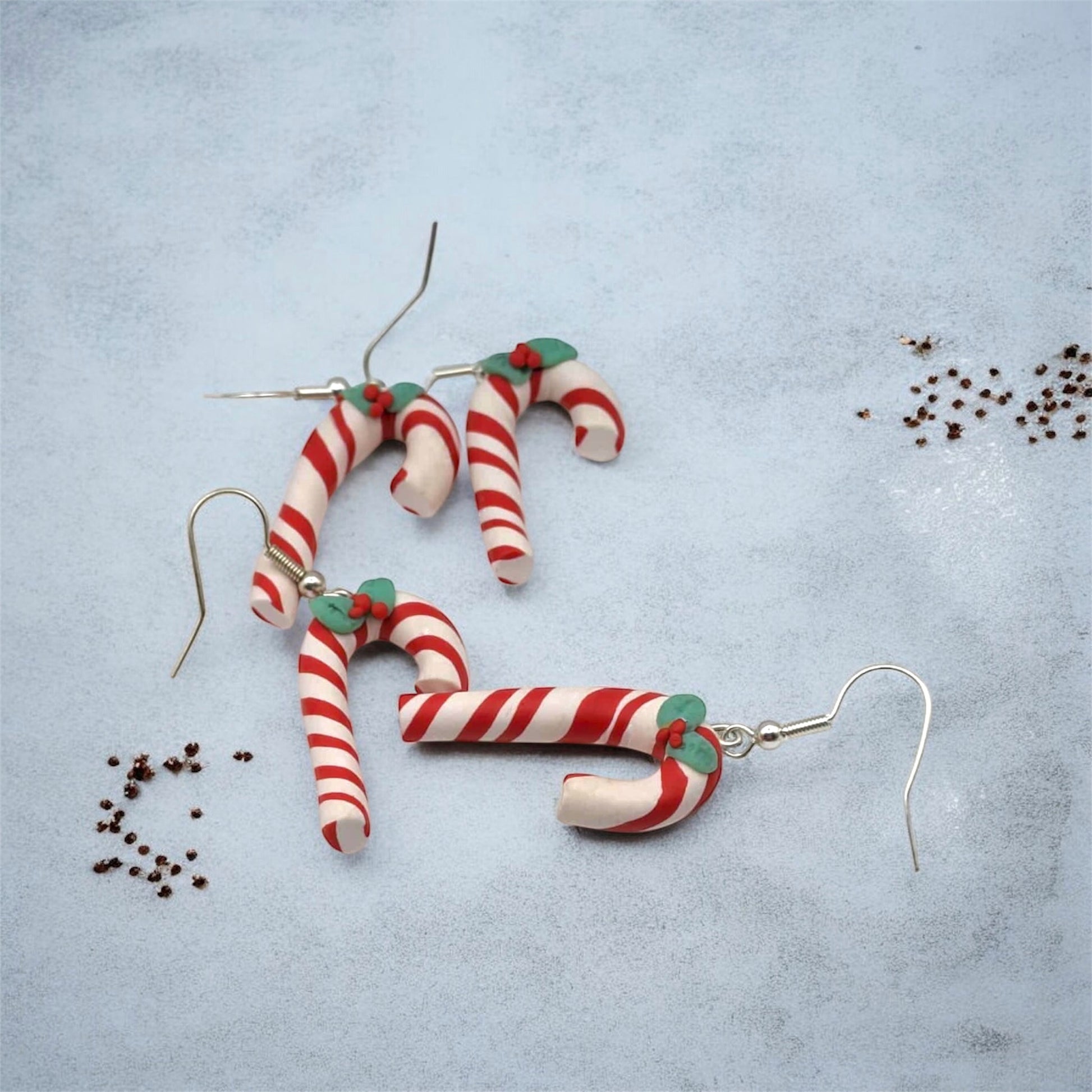 Candy cane-shaped earrings on a light blue background