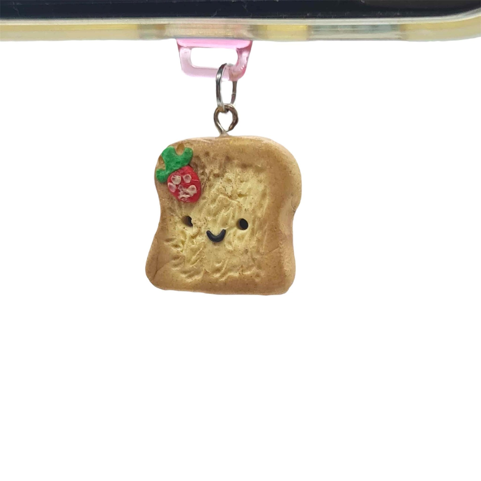 Small charm shaped like a piece of bread with a face on a white background