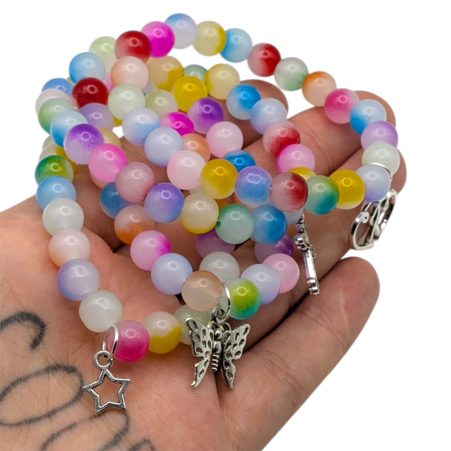 Beaded bracelets with colorful glass beads and charms held in hand, showcasing playful accessories.