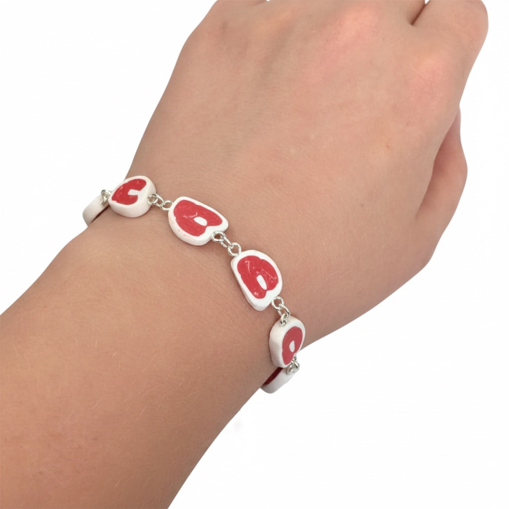 Close-up of the lobster clasp on a red and white raw steak bracelet