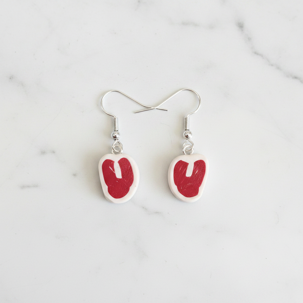 Pair of red and white raw steak earrings polymer clay earrings on a white background 