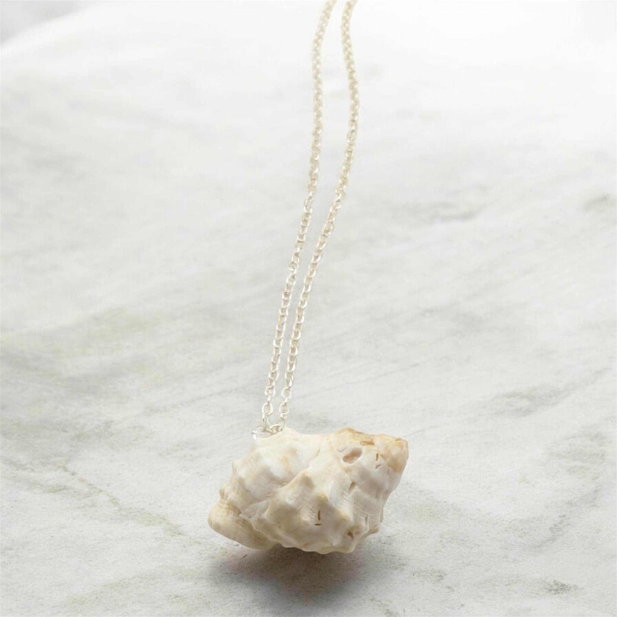 Raw white shell necklace on marble background, handmade by Crystal Seahorse Jewellery