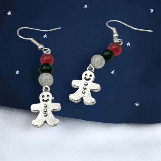 Gingerbread man earrings with colorful beads on a snowy landscape background