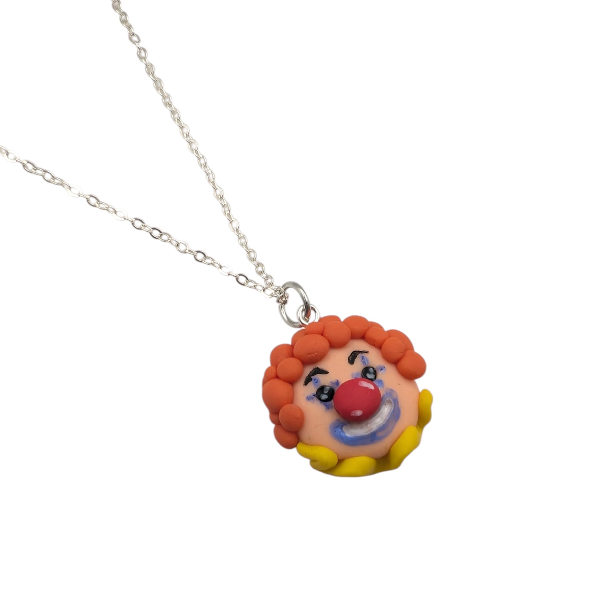 Clown necklace laid flat showing the 18-inch silver-plated chain and pendant