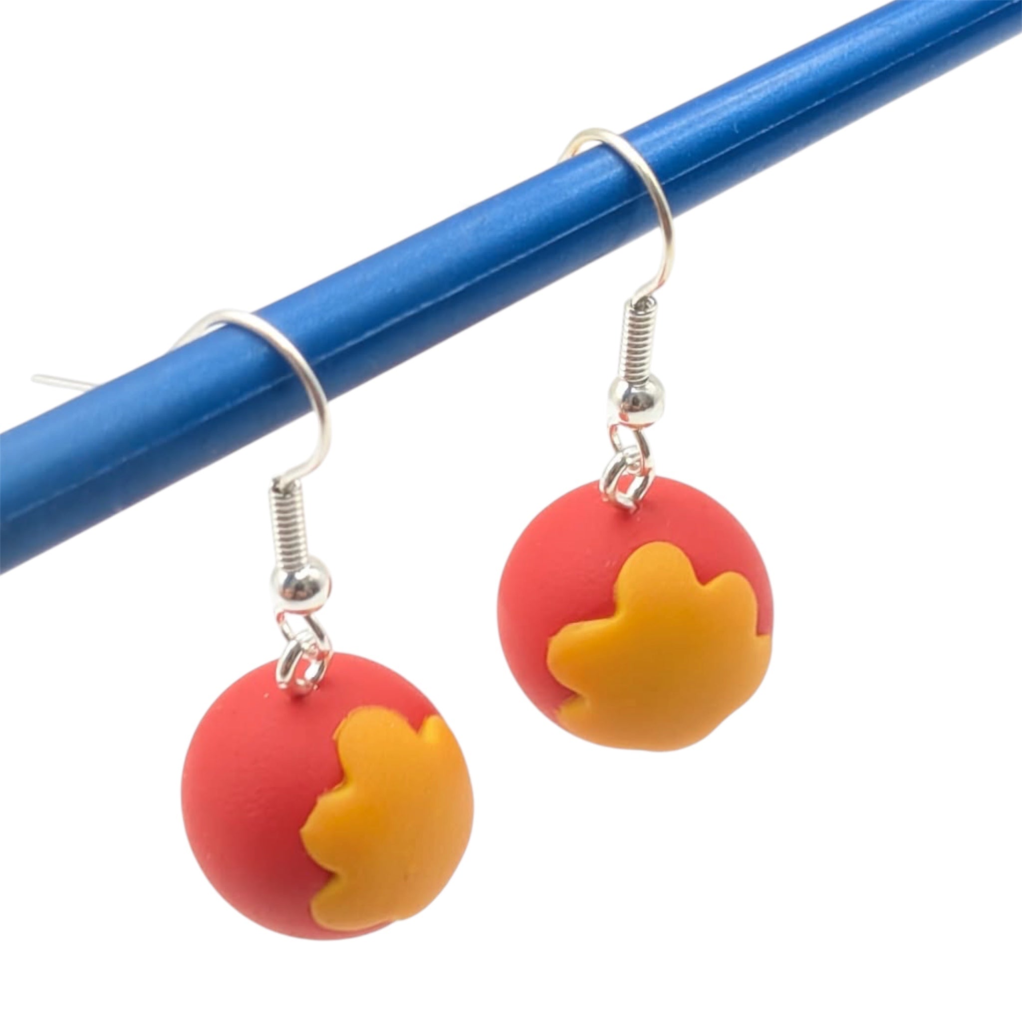 Close-up of hand-sculpted charm on these circus ball earrings with silver-plated ear hooks