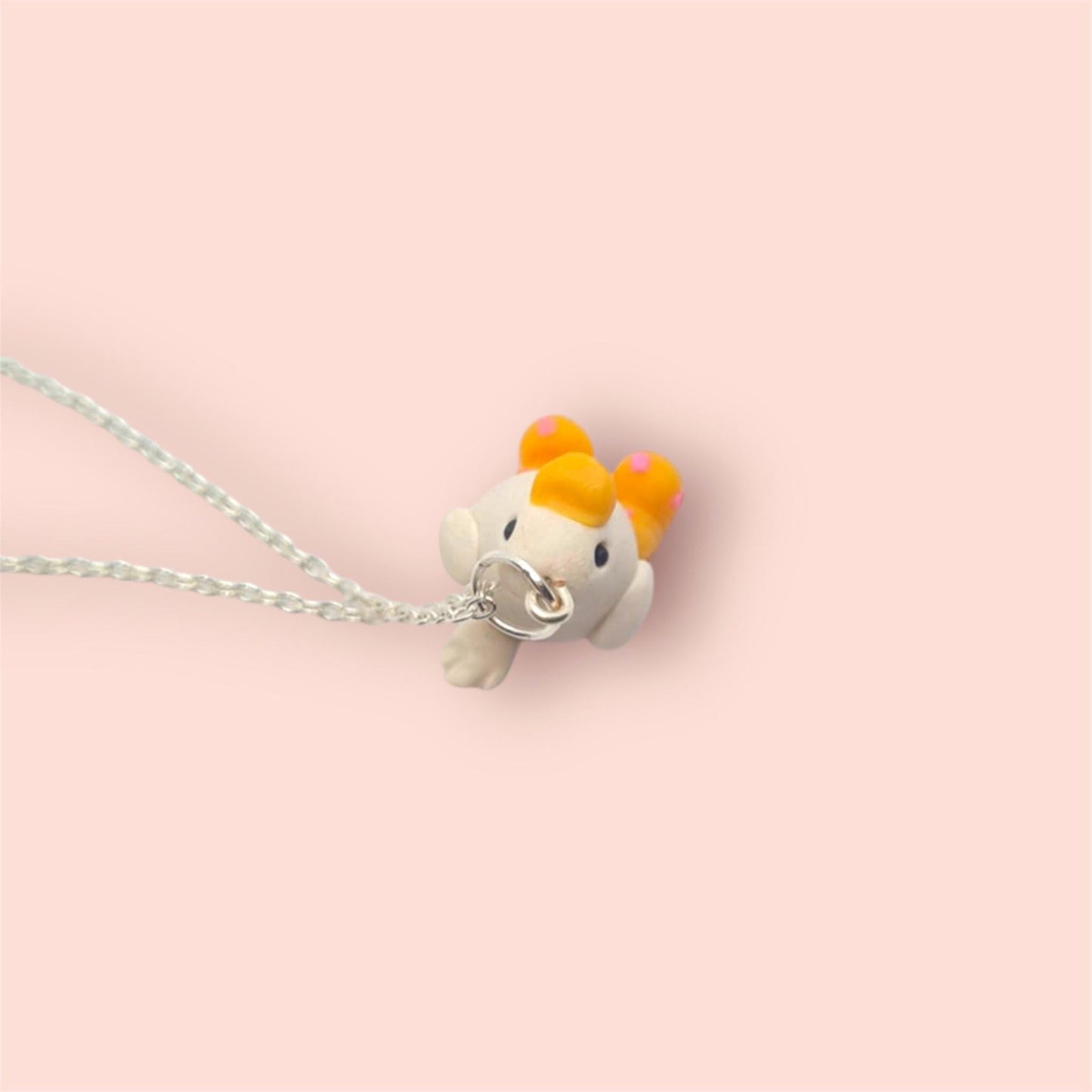 Necklace with a small dog-shaped pendant on a pink background