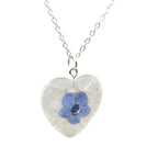 Heart-shaped pendant with a blue flower on a white background