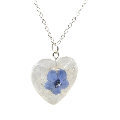 Heart-shaped pendant with a blue flower on a white background
