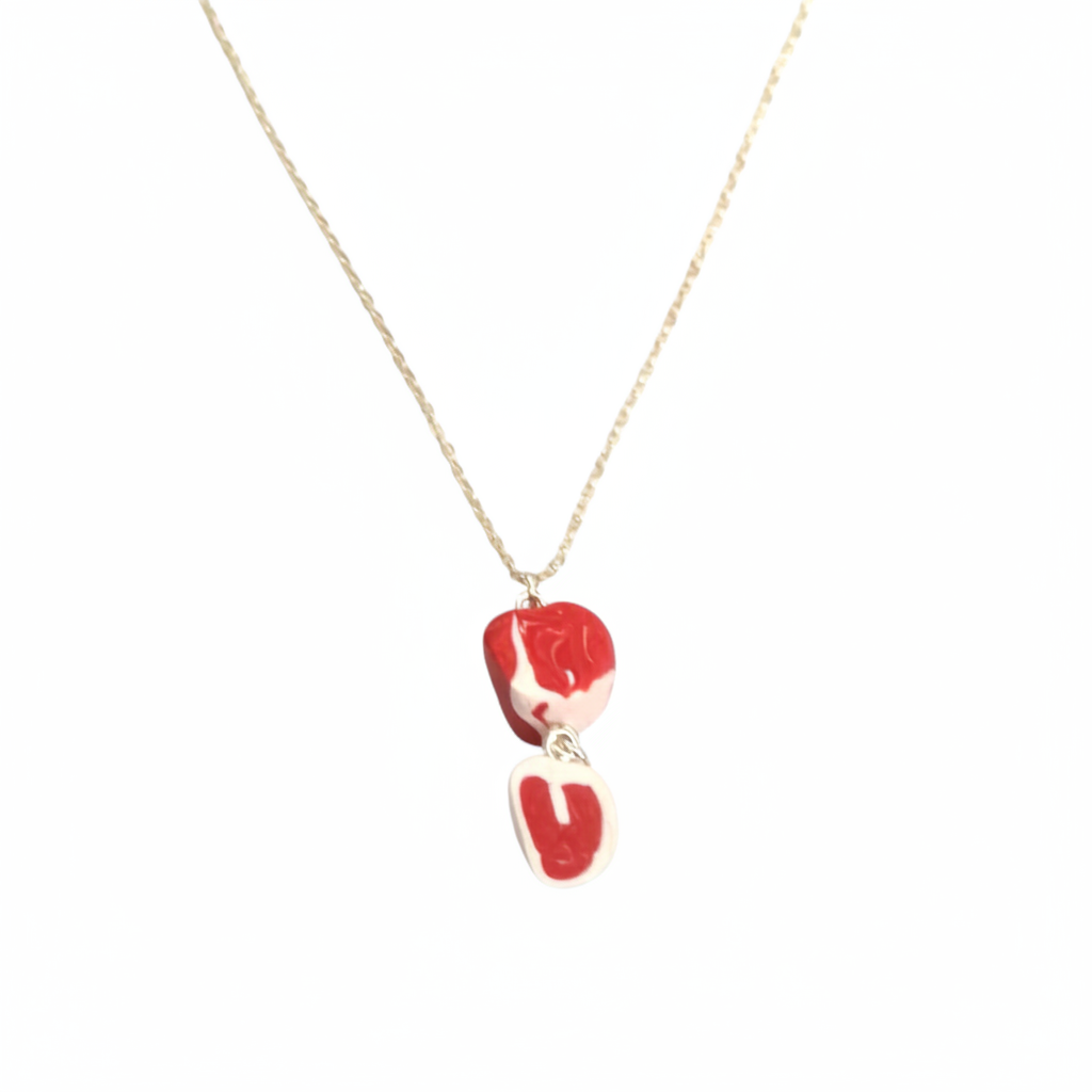 Red and white raw steak necklace laid on a white background