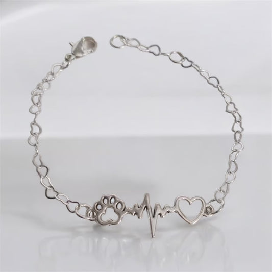Paw bracelet featuring a paw print, heartbeat, and heart charm in silver, perfect for dog lovers.