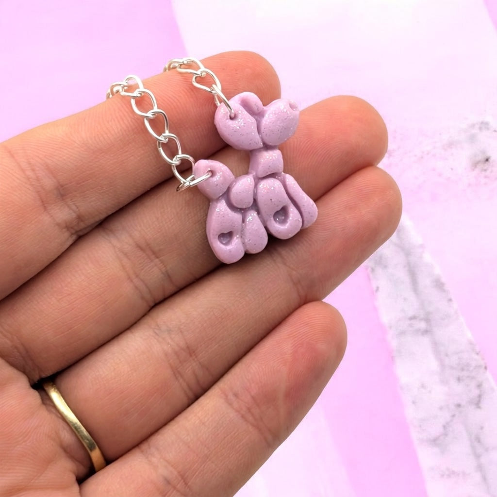 Close-up of red balloon dog necklace pendant with sparkles