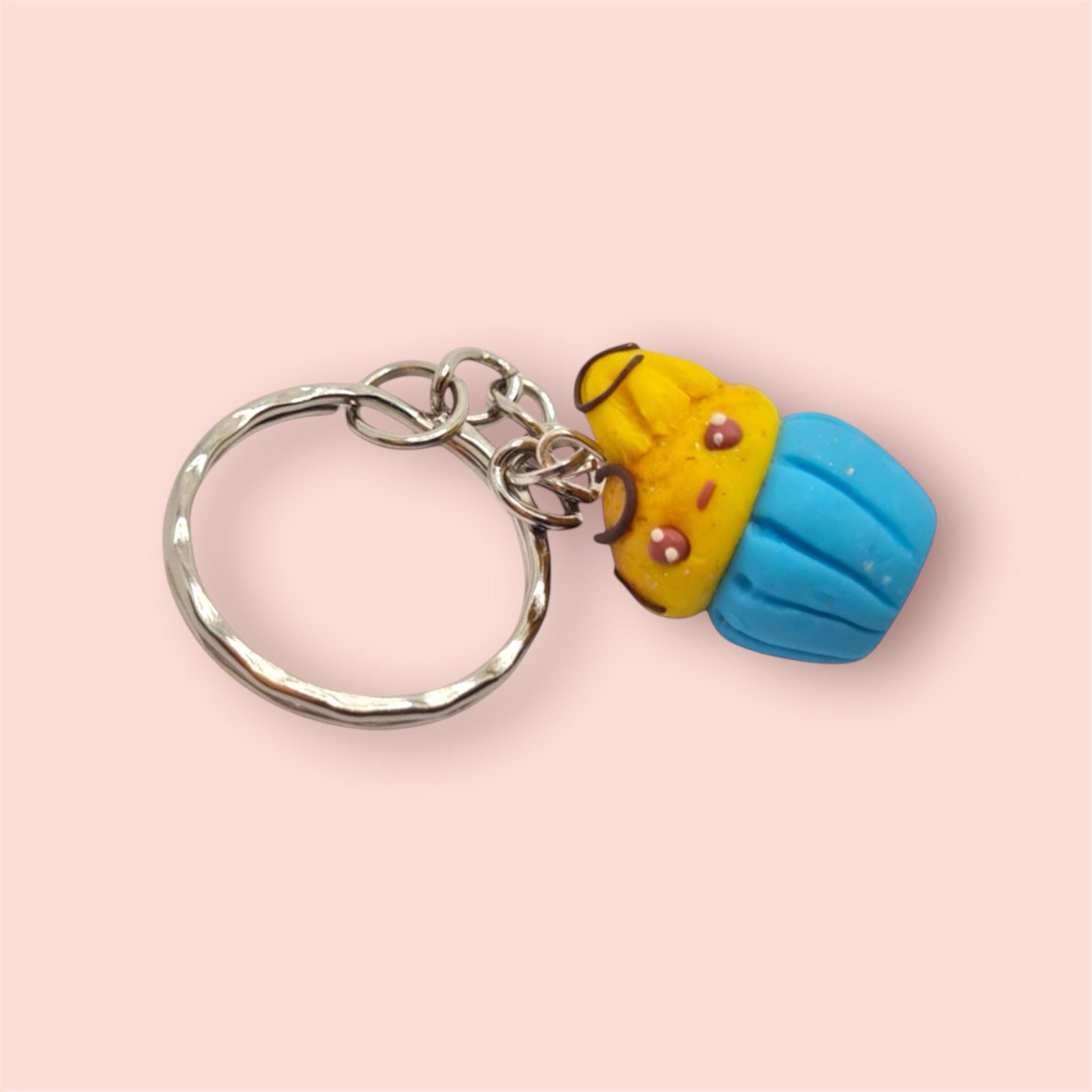 Keychain with a yellow and blue character on a pink background