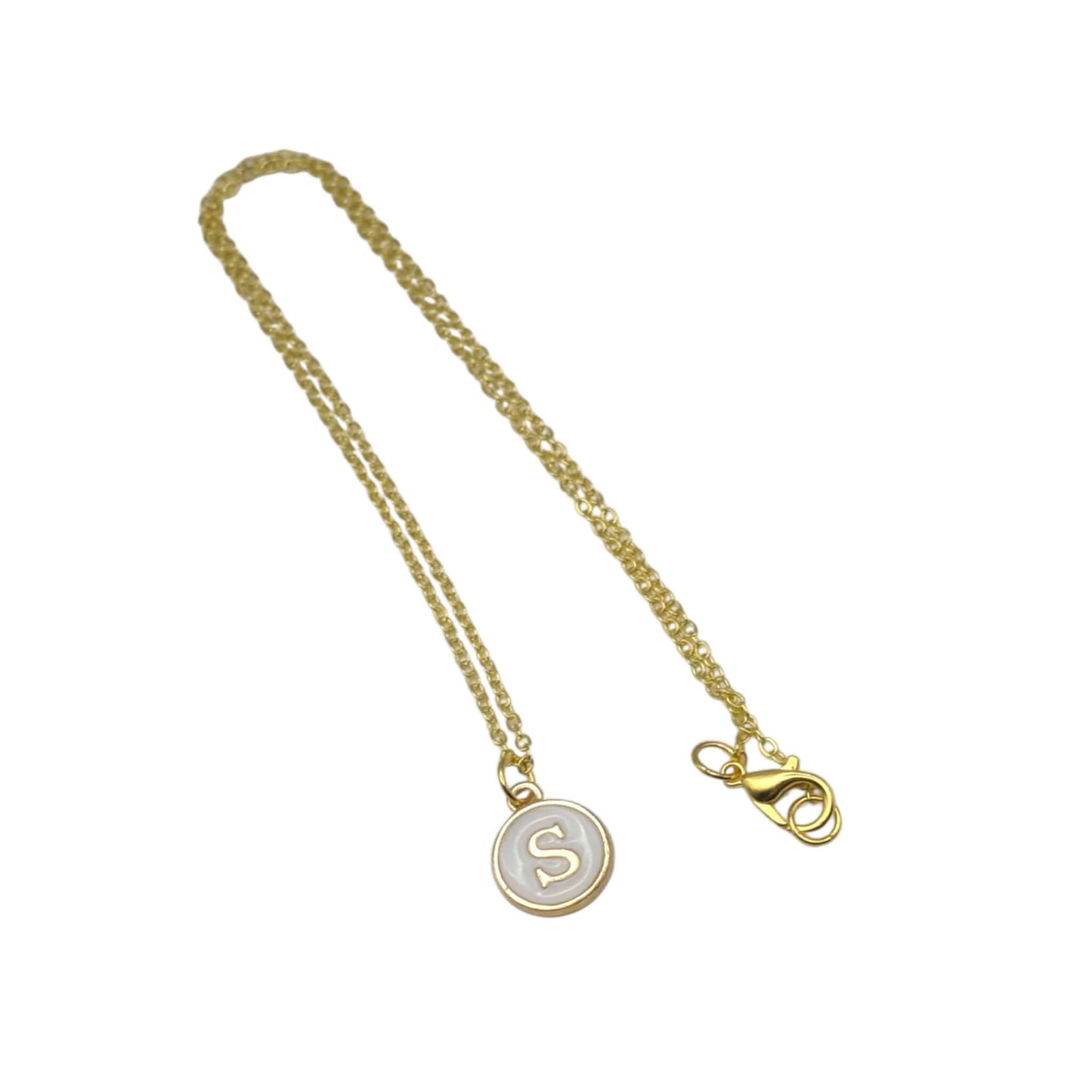 Gold necklace with a pendant featuring the letter 'S' on a white background