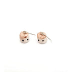 Pair of small round earrings with a textured surface on a white background
