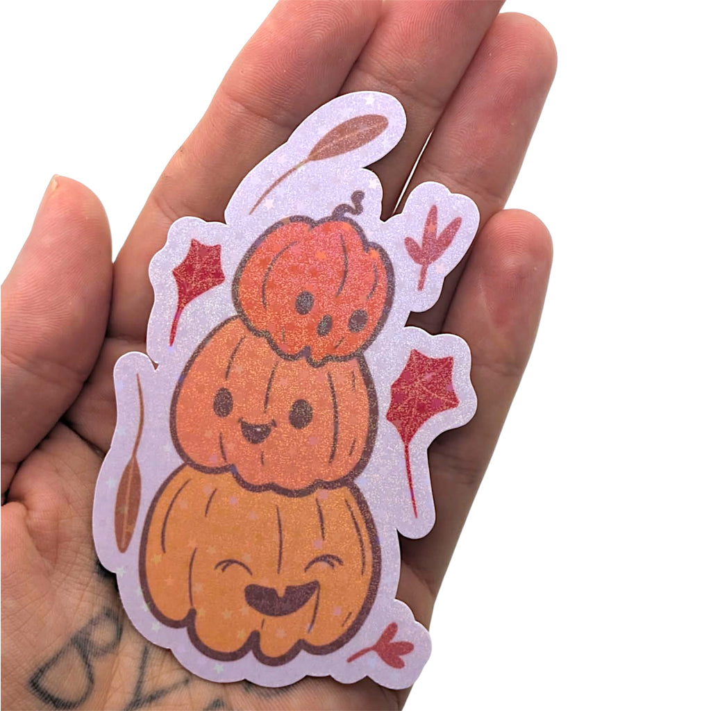 Hand holding a cute pumpkin sticker with a white background