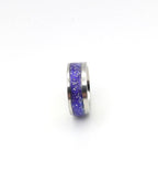 Silver ring with purple glittery band on a white background