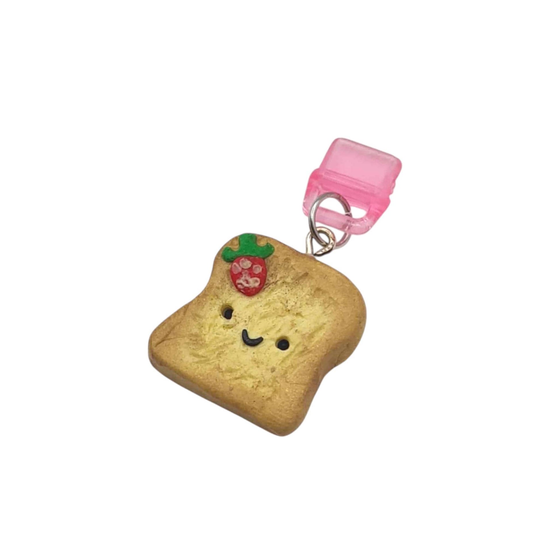 charm shaped like a piece of bread with a smiley face on a white background