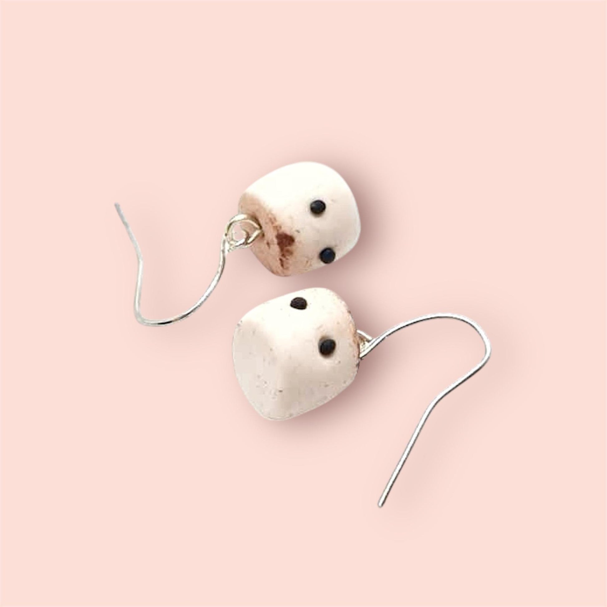 Pair of earrings with toasted marshmallow polymer clay charms on a light pink background 