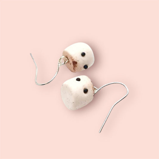 Pair of earrings with toasted marshmallow polymer clay charms on a light pink background 