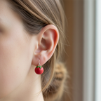 Handmade tomato polymer clay earrings close up worn in ear, silver-plated hooks
