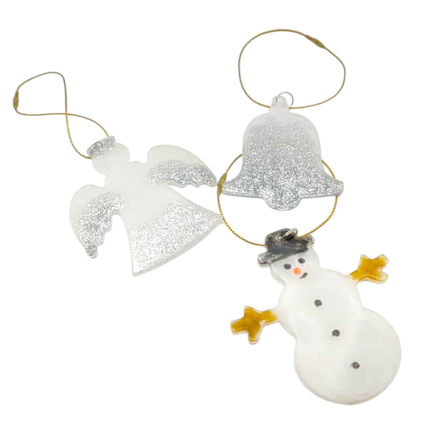 Three Christmas ornaments including a snowman, angel, and bell on a white background