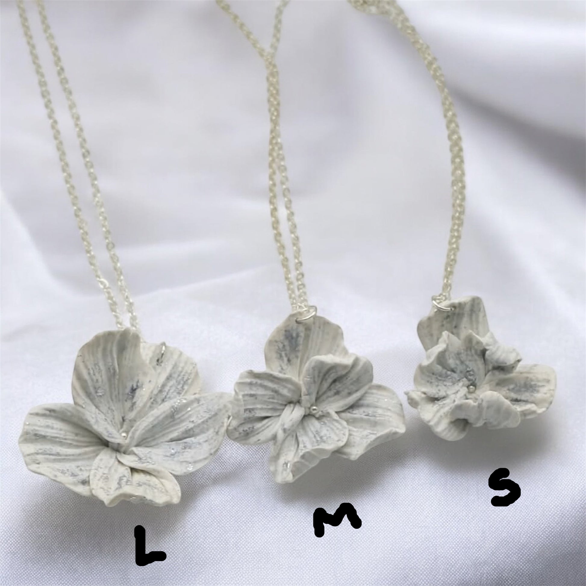 Three white flower necklaces showing small medium and large sizes - wedding jewellery