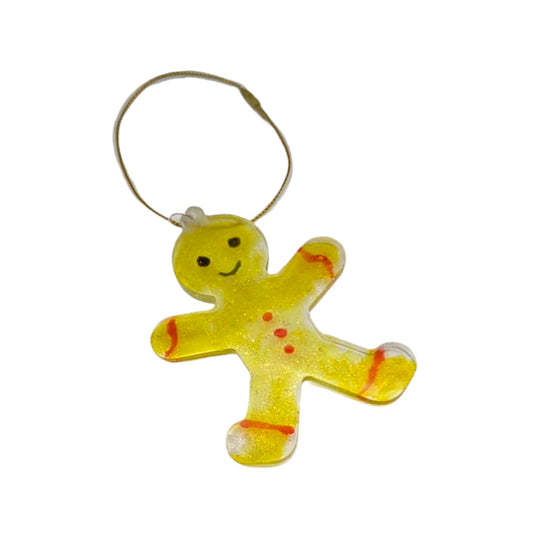 Yellow resin gingerbread man ornament on a white background